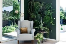 an awkward nook with a living wall, a comfy chair and a table, lots of greenery, it looks very inspiring and refreshing