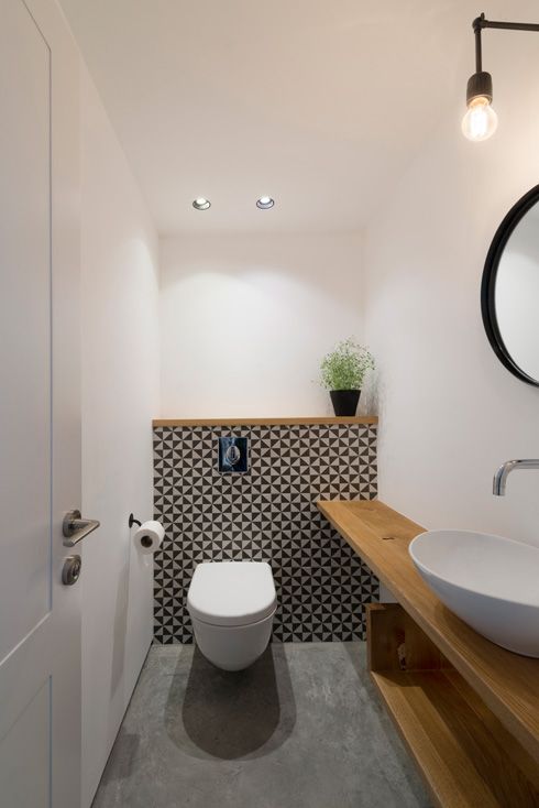 geometric tile wall accentuates the toilet zone and light-colored wood contrasts it perfectly