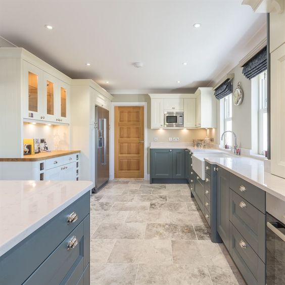 grey and ivory kitchen in farmhouse style with metallic touches and a tile floor