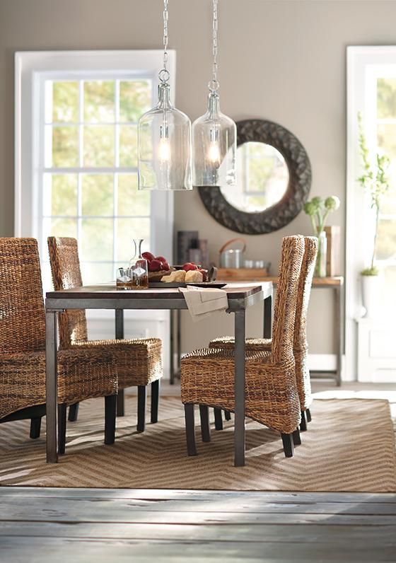modern wicker chairs and an industrial table are great for a farmhouse dining space