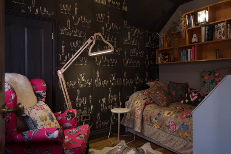 Another guest space features unique black and white printed wallpaper, floral embroidery textiles and a colorful chair