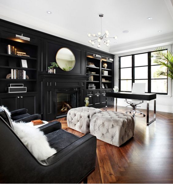 a luxurious space with white walls and a black one taken by cabinets, black chairs and a desk finish off the look