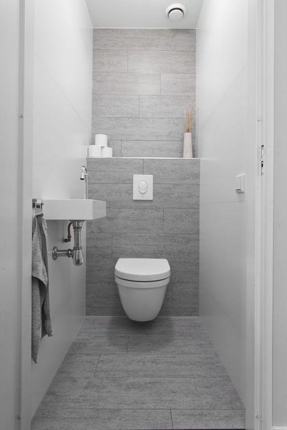a grey wood-looking tile wall and floor make an accent in this neutral space