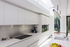13 a long narrow minimalist white kitchen with a metal backsplash and skylights to bring much light in