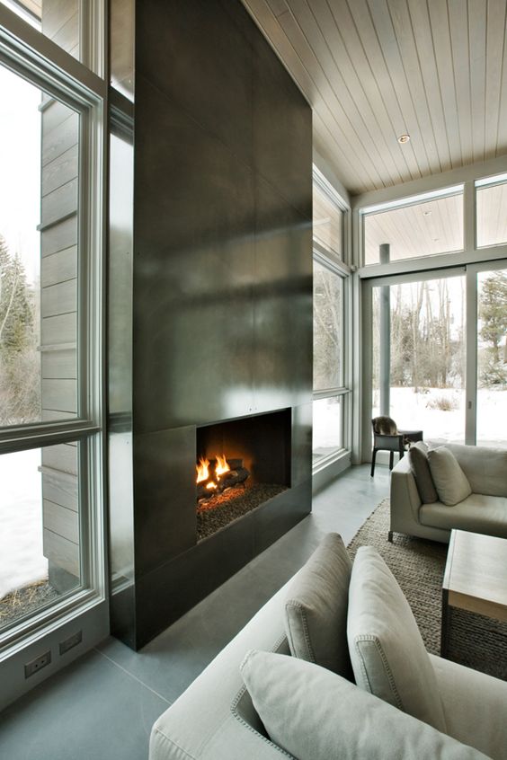 an ultra-modern fireplace clad with dark metal sheets looks very eye-catching and even show-stopping