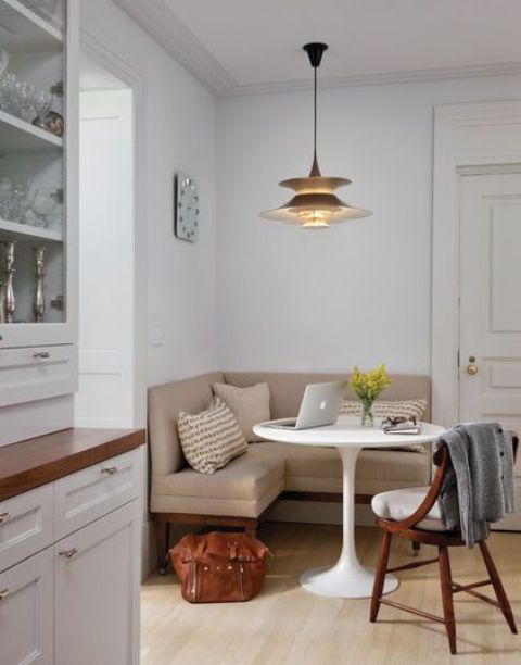 a cozy eating space in a small corner, a corner sofa and an eye catchy hanging lamp over it