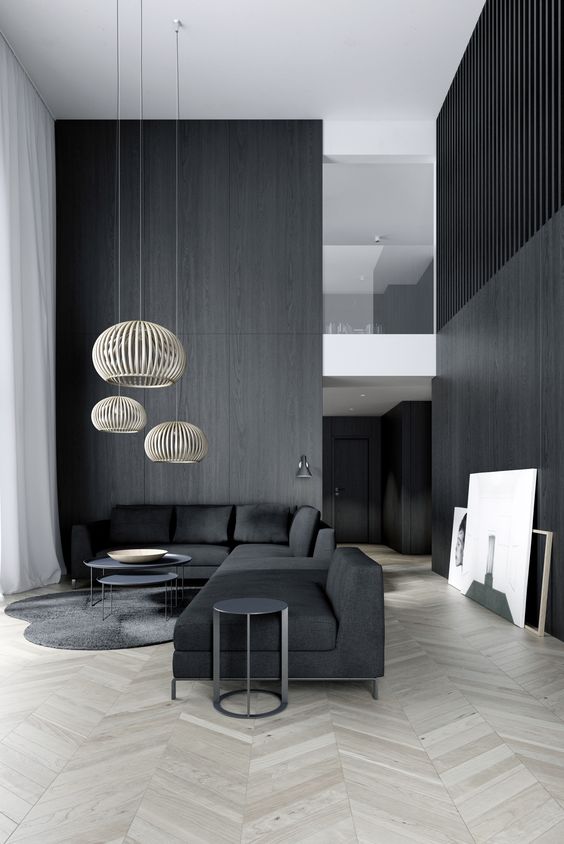 a minimalist space with black wooden walls and furniture, cool pendant lamps highlight the double height ceiling