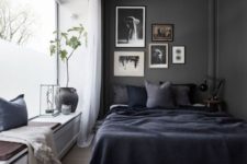 16 a Scandinavian bedroom is made more relaxing and comfortable with a black wall, and a large window creates a balance betwene dark and light