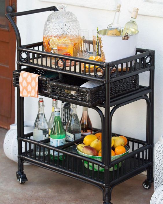 a black bar cart on casters with wicker baskets for storage is a great mobile piece
