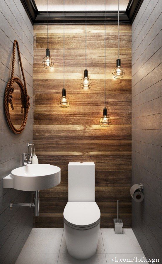 a wood accent wall and lots of industrial geo bulbs hanging over the toilet