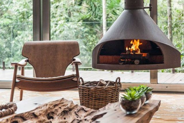 a chic wood burning fireplace hanging next to a chair creates a cozy nook