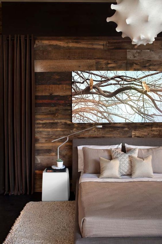 a stylish modern bedroom in shades of brown is added interest with a reclaimed wood wall