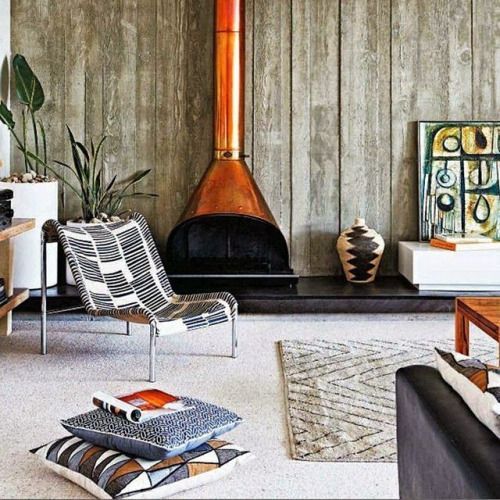 a boho space with bold details and an orange metal free-standing malm fireplace looks wow