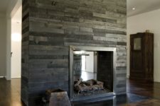 19 a double-sided fireplace clad with reclaimed grey and black wood brings texture and a cool look to the space