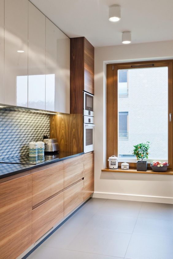 a cozy modern space with ivory and natural wood cabinets and a monochromatic geometric backsplash