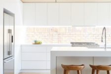 20 a minimalist white kitchen with a wooden ceiling, stools and an eye-catchy backsplash
