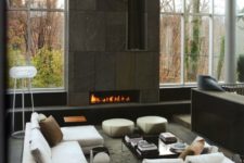 21 a double-height fireplace clad with dark patterned tiles and with vertical firewood storage