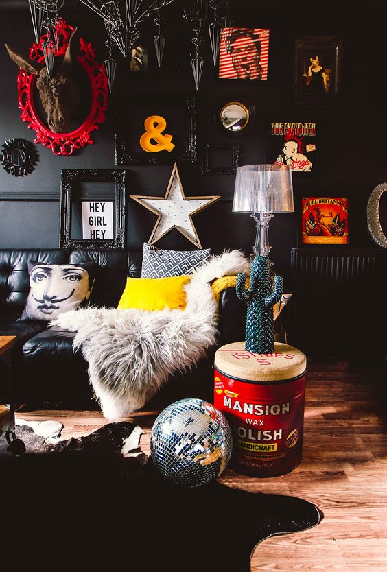 a pop art living room with black walls and furniture and lots of artworks and decorations to make it really eye-catching