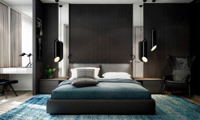 a dark space with vertical wooden sltas on the wall, a dark upholstered bed, black hanging lamps and dark linens
