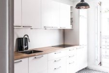 23 a modern white kitchen with a geometric floor and a wooden countertop to make it look more interesting