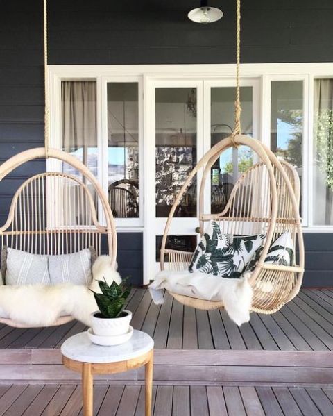 hanging rattan chairs with pillows and faux fur to feel comfy in your porch