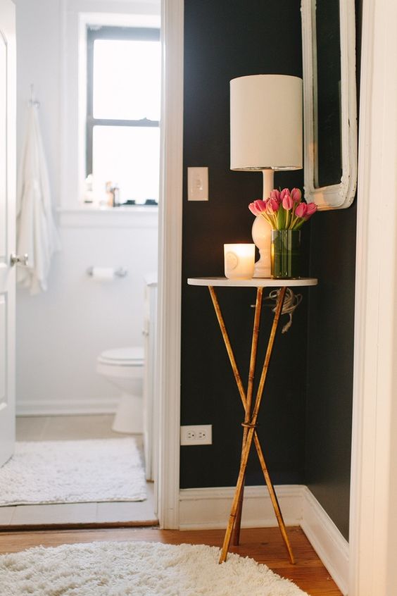a tiny side table with a candle, lamp and soem fresh blooms on metallic legs is ideal for a tiny corner