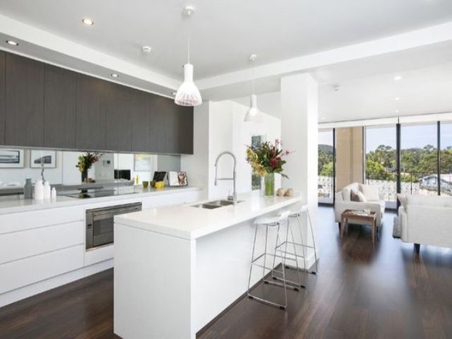 a minimalist space with white and dark stained wooden cabinets and a white kitchen island looks sleek and chic