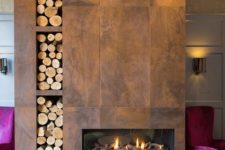 26 this beautiful fireplace is clad with tiles that imitate aged metal or wood, with a firewood storage