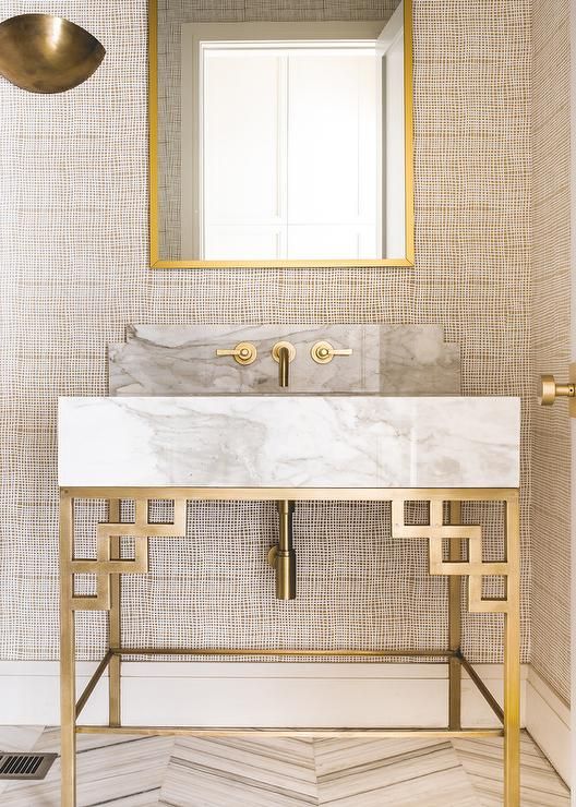 a very eye-catching marble vanity with gilded geometric legs and framing looks wow