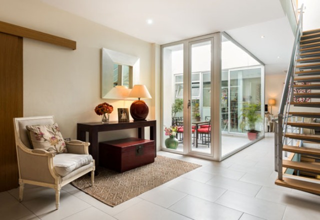 The interior is done in neutral tones and features several red leather trunks used for storage and as coffee tables The interior is done in neutral tones and features several red leather trunks used for storage and as coffee tables