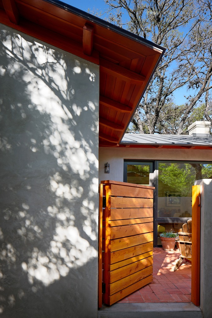 The patio is protected with a concrete fence and a wooden door to make it more private