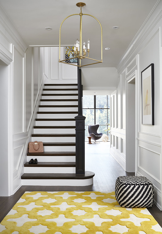 entryway decor with a colorful rug It continues with a colorful rug and a geometric ottoman