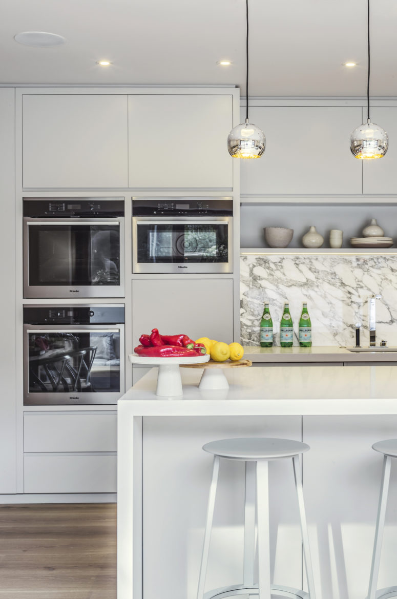 The appliances are built-in and the backsplash is marble