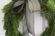 03 an elegant evergreen wreath with a pinecone and a grey ribbon bow