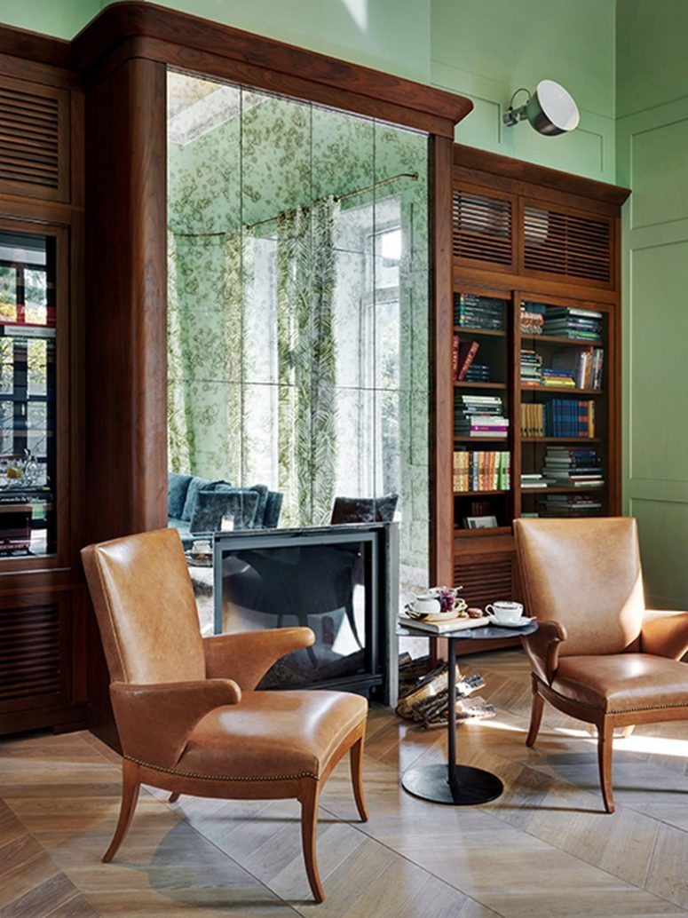 Look at this adorable fireplace integrated into the bookcases with a mirror wall - it's an eye-catcher