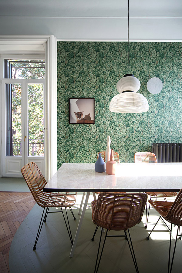 The dining space is done with a dining table and wicker chairs