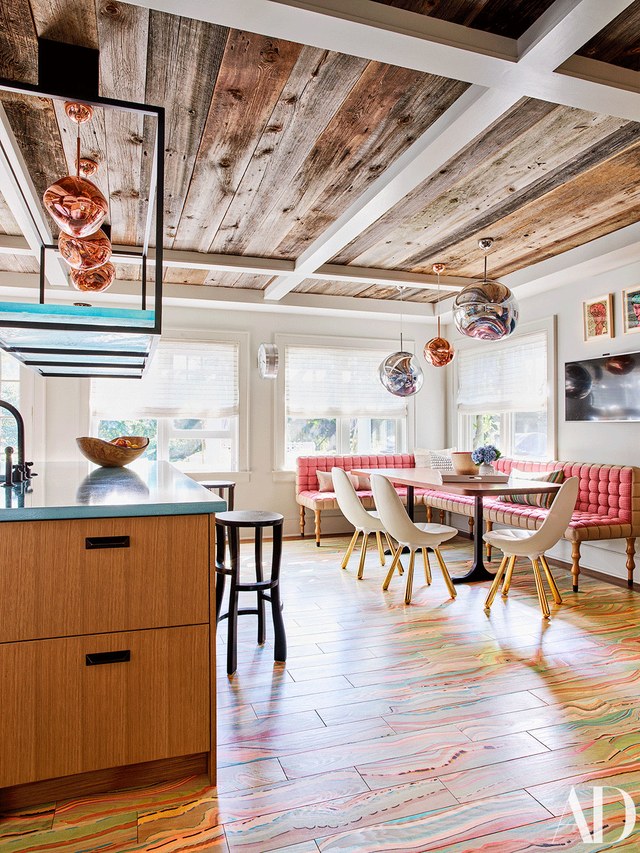 The kitchen is decorated with the shades of mint and pink, there's unique tile floor and an upholstered bench