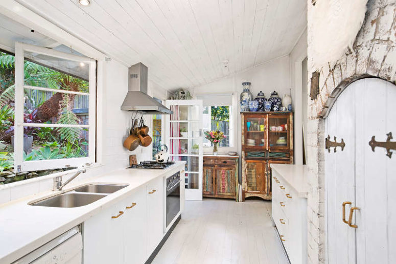 The kitchen is eclectic, there's modern sleek furniture and colorful shabby chic pieces, and some brick clad adds a texture