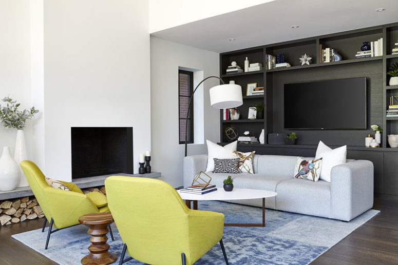 The sitting space united with the dining one is done with neon yellow chairs and a grey TV wall unit The sitting space united with the dining one is done with neon yellow chairs and a grey TV wall unit