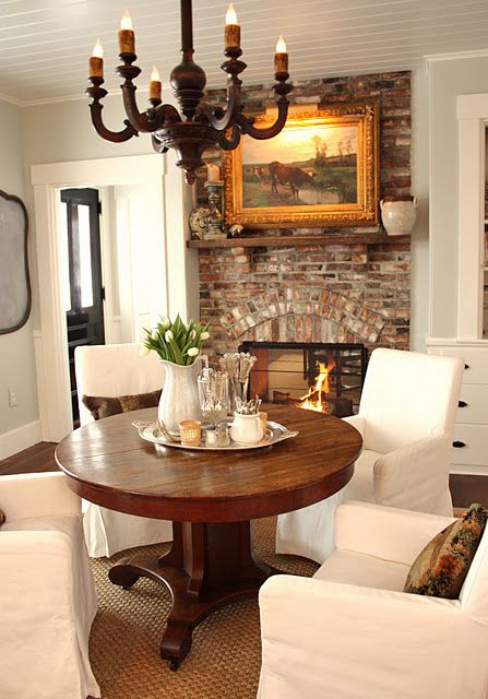 a cozy breakfast zone by the fireplace with a rich-colored wood pedestal table
