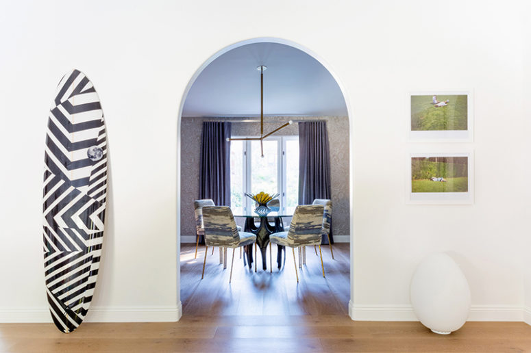 The dining space is done with a round glass table and printed upholstered chairs