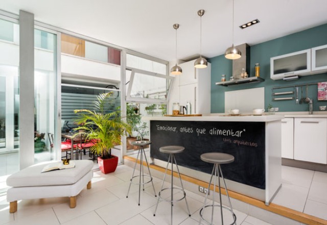 creative chalkboard kitchen island The kitchen features a chalkboard kitchen island and it's located on a platform to separate the space