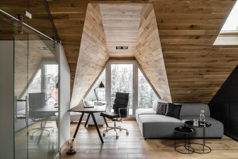 The workspace is done with a desk, a comfy chair and a small corner sofa in grey