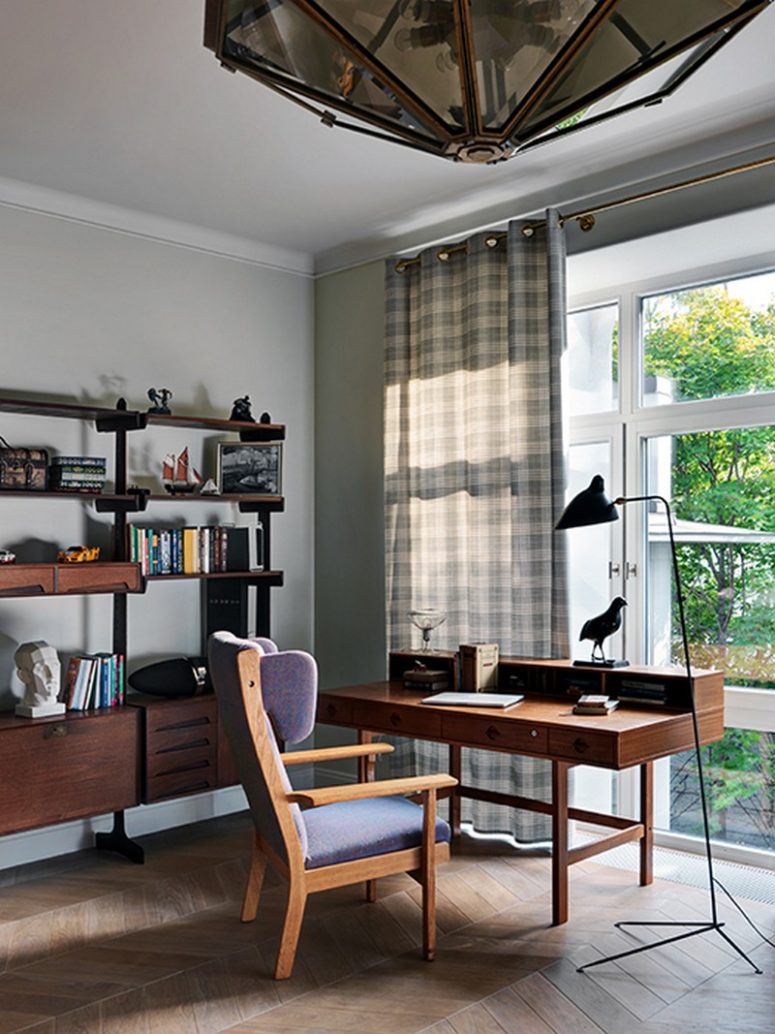 The home office breathes with mid-century modern vibes, there's a comfy storage unit and a vintage desk