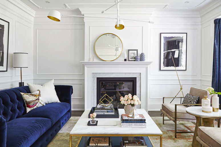 The living room is done with a navy sofa and curtains, with a built in fireplace and mauve chairs, metallic touches make the space chic The living room is done with a navy sofa and curtains, with a built-in fireplace and mauve chairs, metallic touches make the space chic