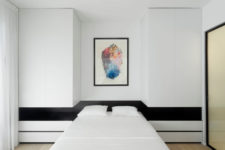 06 The master bedroom is done in black and white, with stripes, a colorful artwork