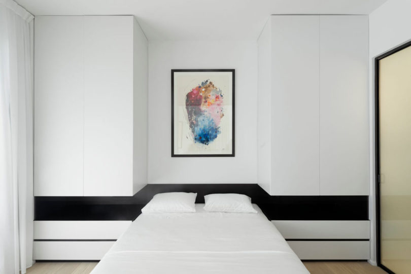 The master bedroom is done in black and white, with stripes, a colorful artwork