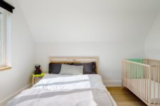 07 The bedroom features a bed, a colorful geo rug and a baby’s crib