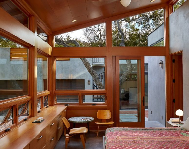 The bedroom is fully glazed but the privacy is kept because it comes to the inner patio, and you can see much wood inside, it ties indoors and outdoors