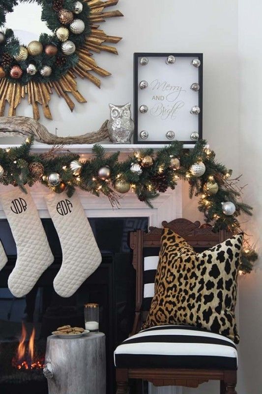 a faux fir wreath and garland with metallic ornaments, a sign with silver ornaments
